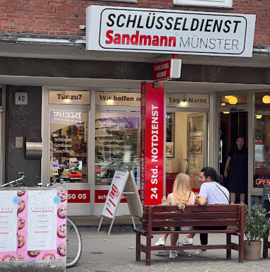Schlüsseldienst Sandmann Münster Außenansicht des Geschäfts Schlüsseldienst Sandmann Münster mit Ladenschild und Schaufenster
